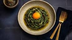 Green spaghetti with golden egg yolk and chilli gremolata