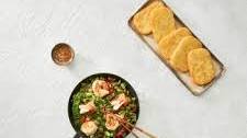 Rectangular hash browns with stir-fry with edamame beans, bell peppers, snow peas, and scallions