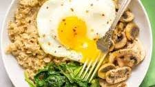 Savory oatmeal bowl with mushrooms, spinach and fried egg