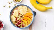 Smoothie bowl With banana, nectarines and pomegranate seeds