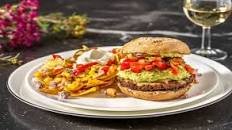 Burger de boeuf au guacamole & cheddar fondu servi avec des nachos et des jalapeños