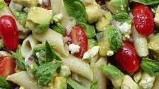 Avocado pasta salad with tomatoes and feta cheese or queso fresco