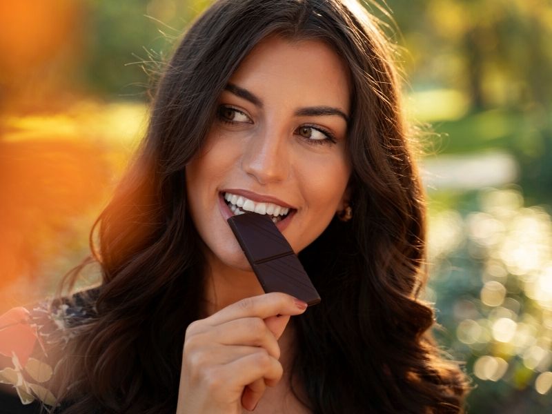 young woman eating dark chocolate