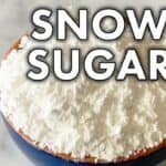 Bowl of snow sugar, a finely powdered sugar used for baking and decorating desserts, with a soft, fluffy texture.