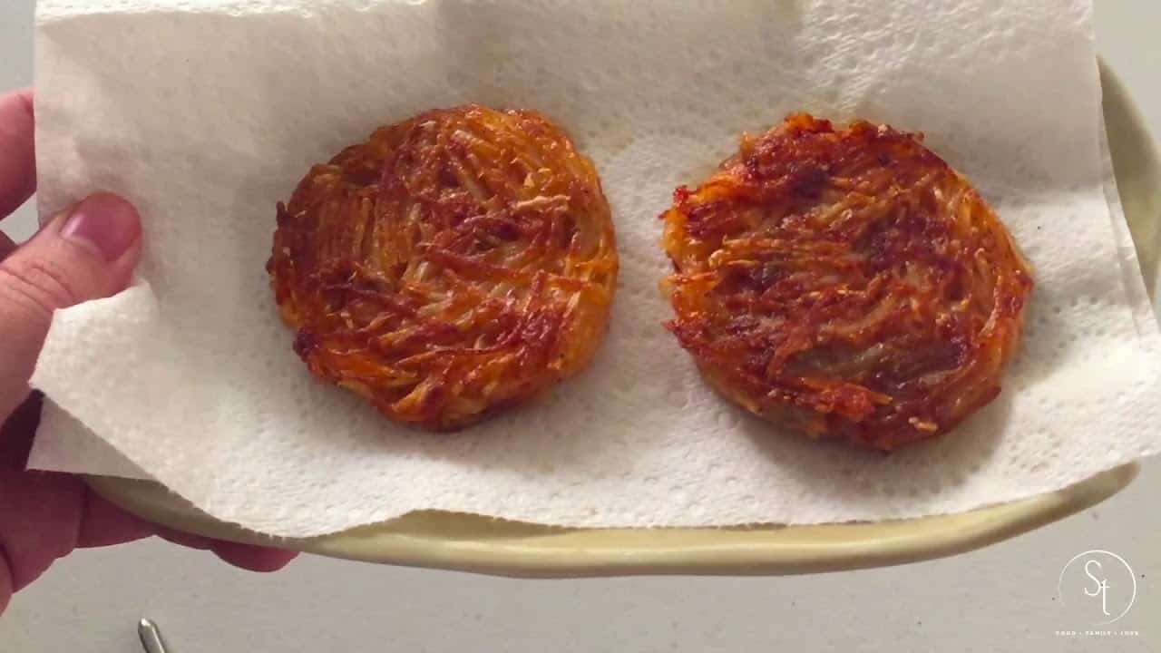 Golden-brown crispy potato pancakes resting on a paper towel, showcasing their crunchy texture and delicious appearance.