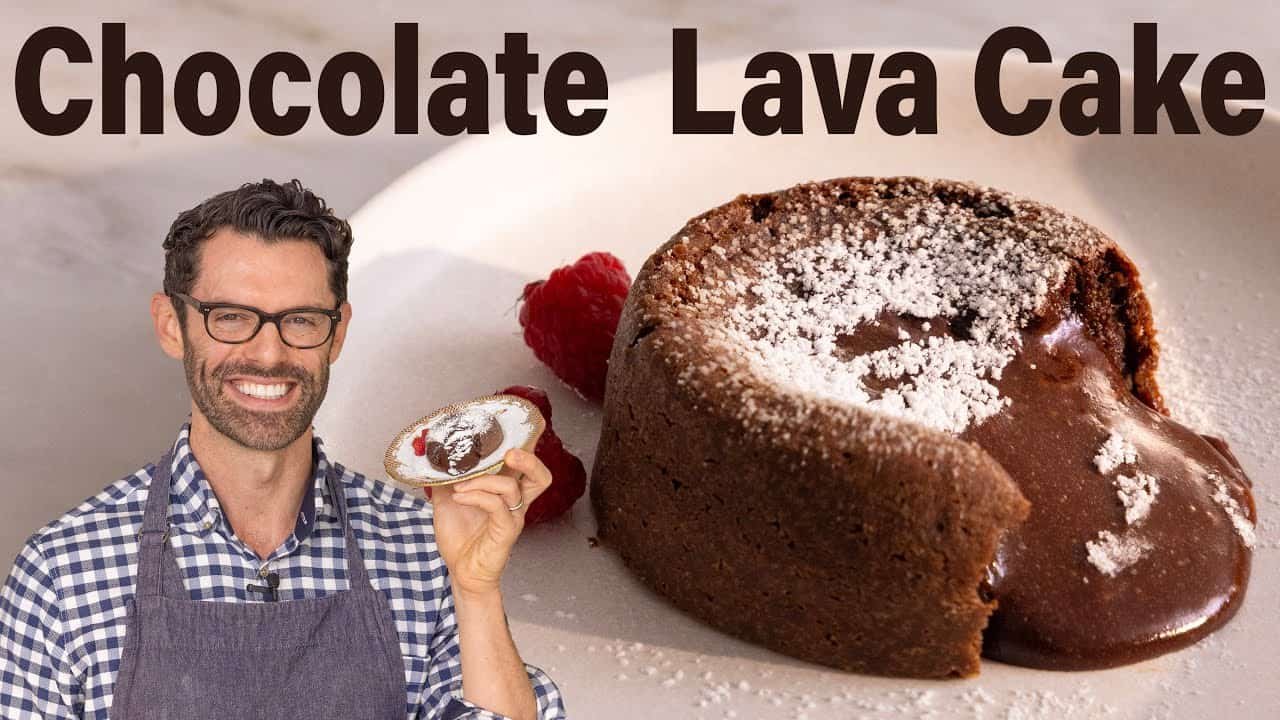 A chef presenting a delicious chocolate lava cake topped with powdered sugar and fresh raspberries, emphasizing the rich, molten center of the dessert.