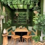 Cozy indoor dining area featuring green foliage, wooden furniture, and a minimalist design, perfect for a relaxed atmosphere.