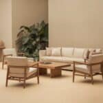 Modern living room with a beige sectional sofa, two matching armchairs, and a wooden coffee table, surrounded by indoor plants and neutral-colored walls. Ideal for contemporary home décor.