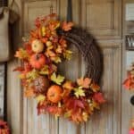 Autumn wreath adorned with colorful leaves, pumpkins, and gourds, hanging on a wooden door, perfect for seasonal home decor.